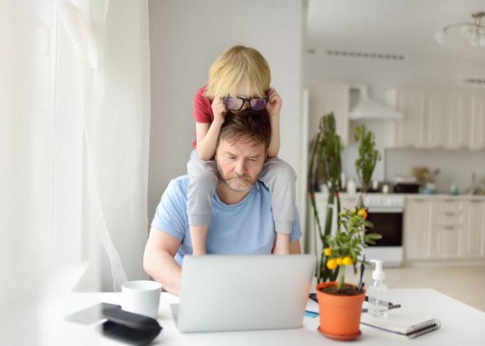 Mężczyzna rozpraszany przez dziecko podczas home office